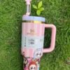 Pink striped character-style tumbler with handle and reusable straw